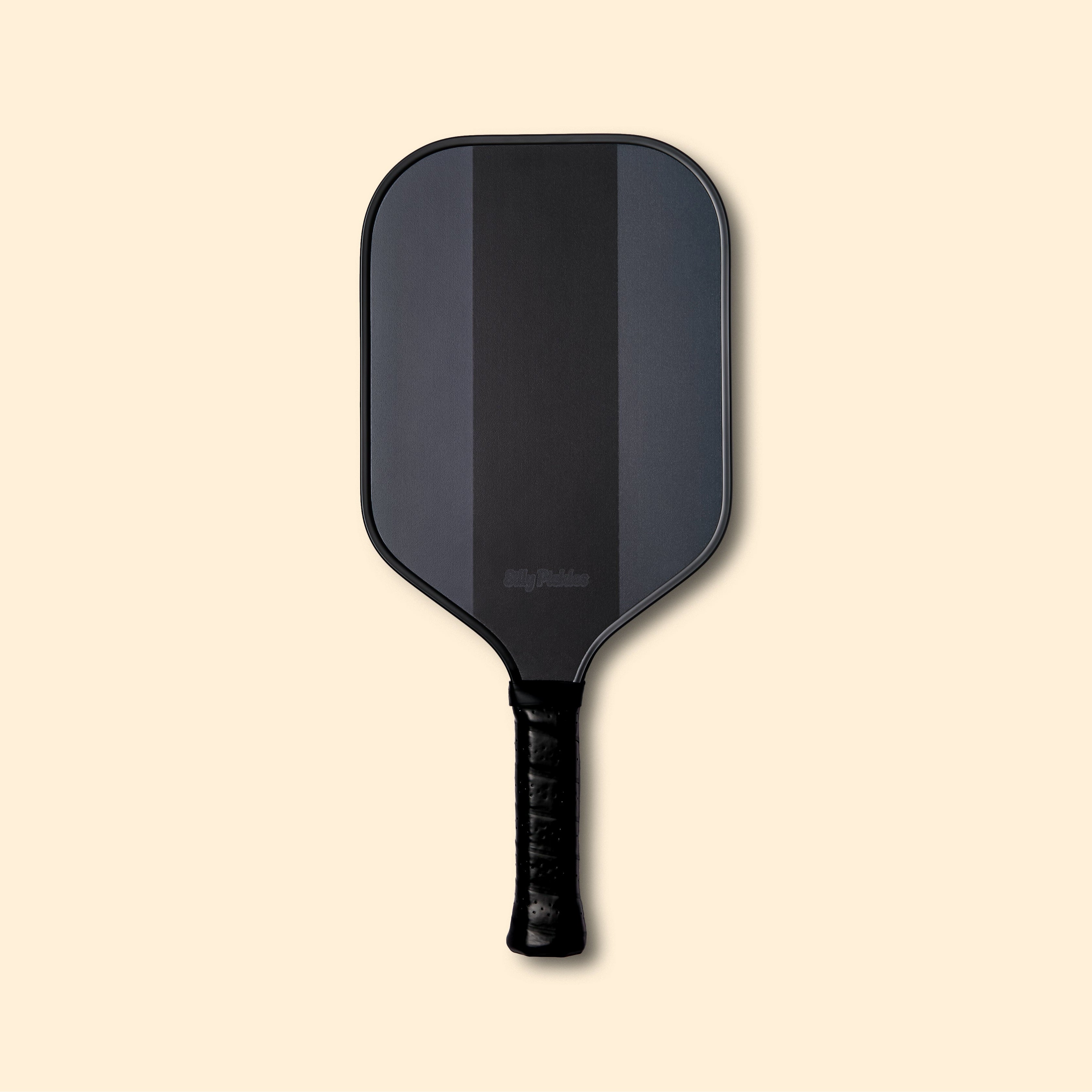Silly Pickles "blackout" pickleball paddle on a beige background
