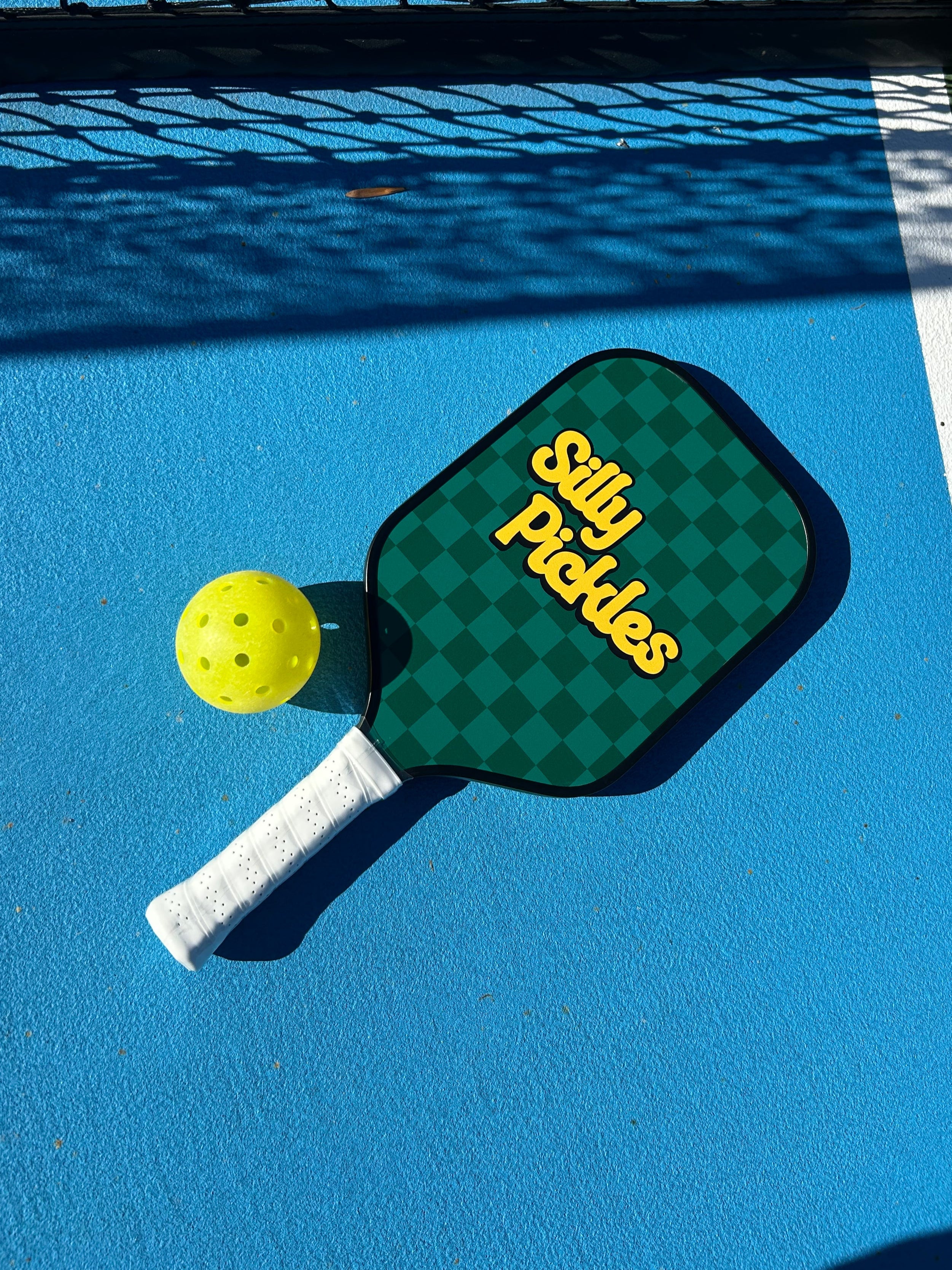Silly Paddles pickleball paddle and ball on a blue court