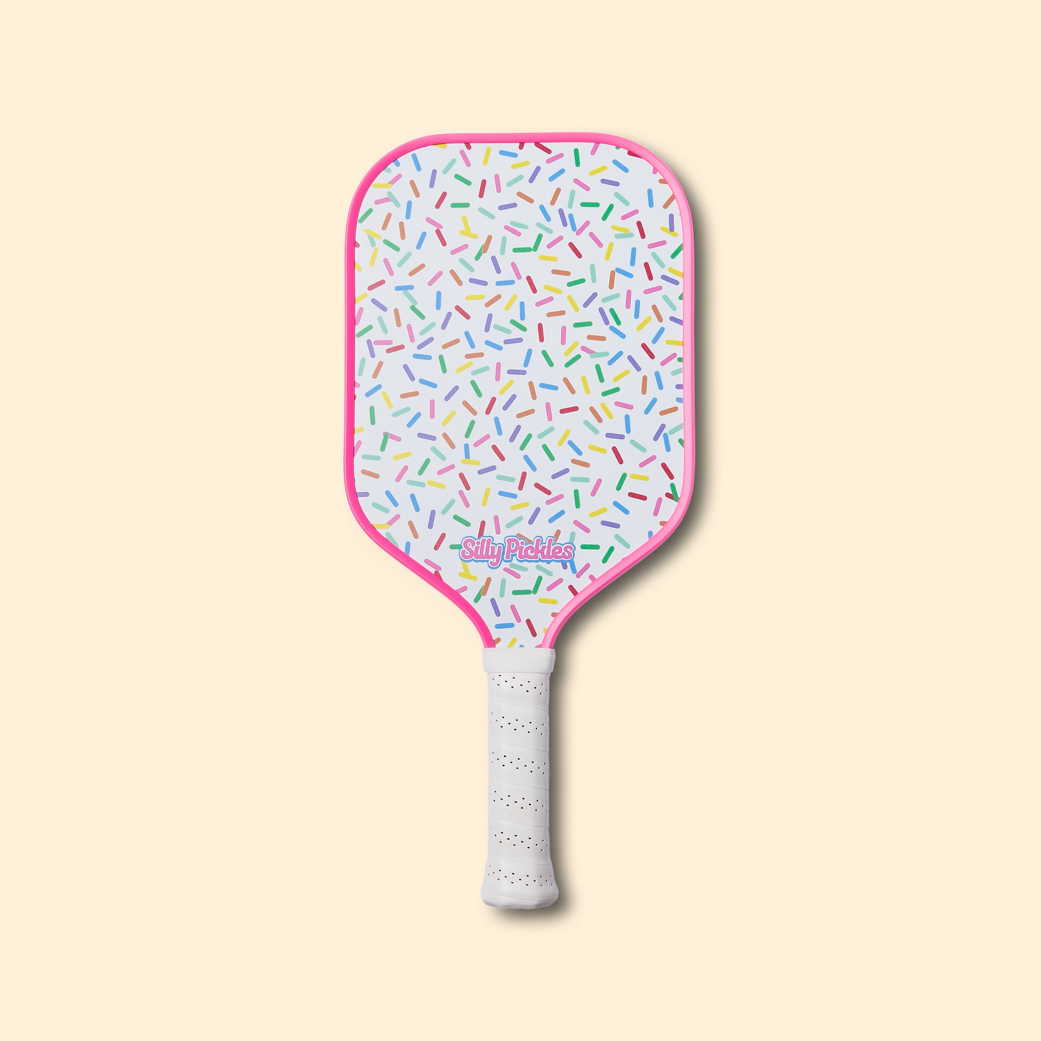Silly Pickles pickleball paddle with colorful sprinkles pattern on a beige background