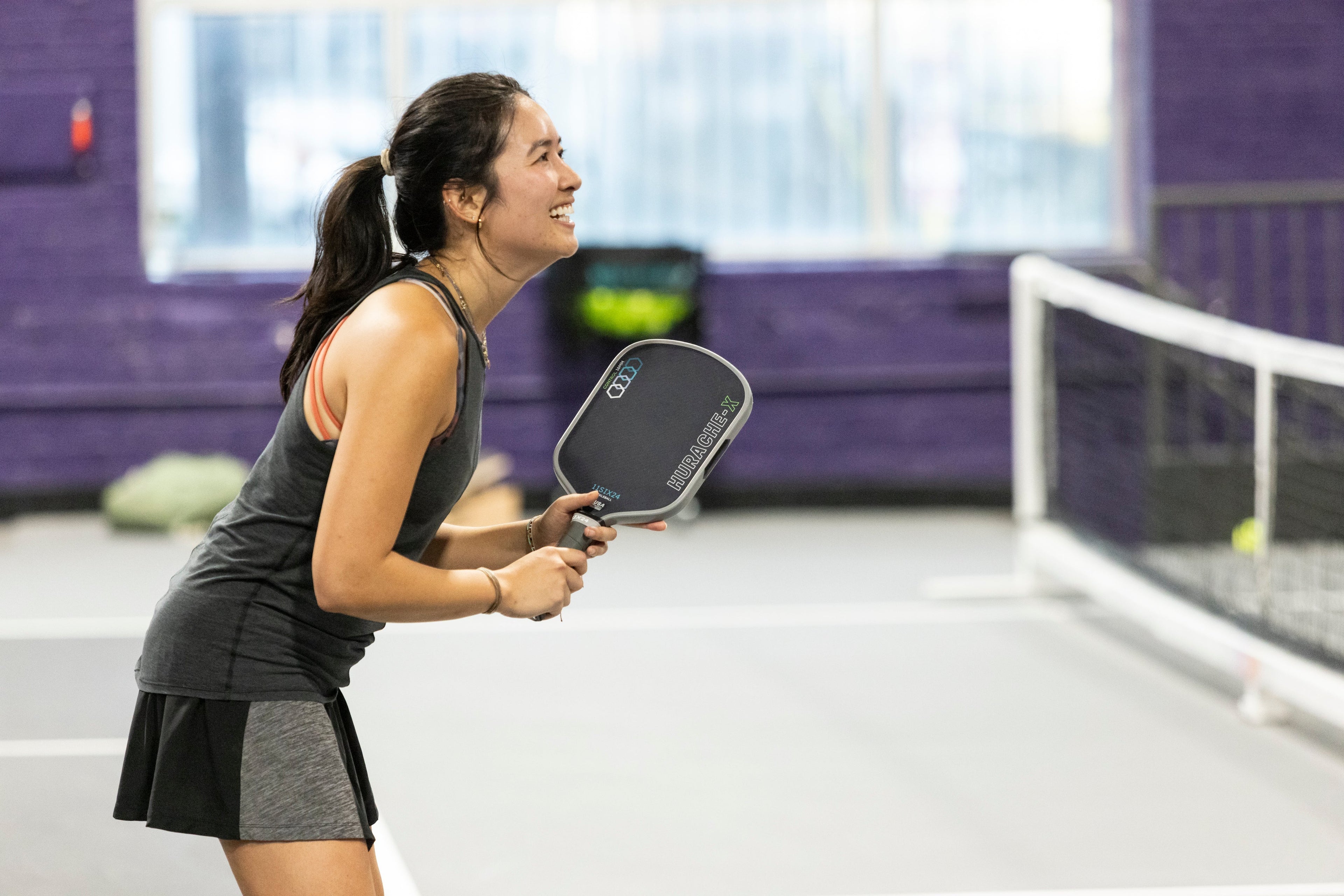 Woman playing pickleball in an indoor court