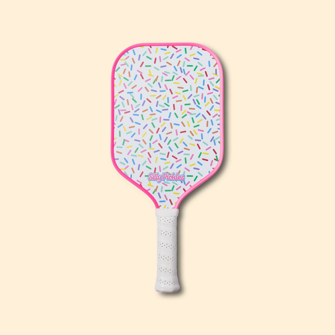 Silly Pickles pickleball paddle with colorful sprinkles pattern on a beige background