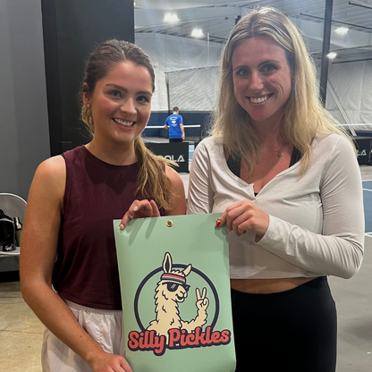 Two women holding a sign with &